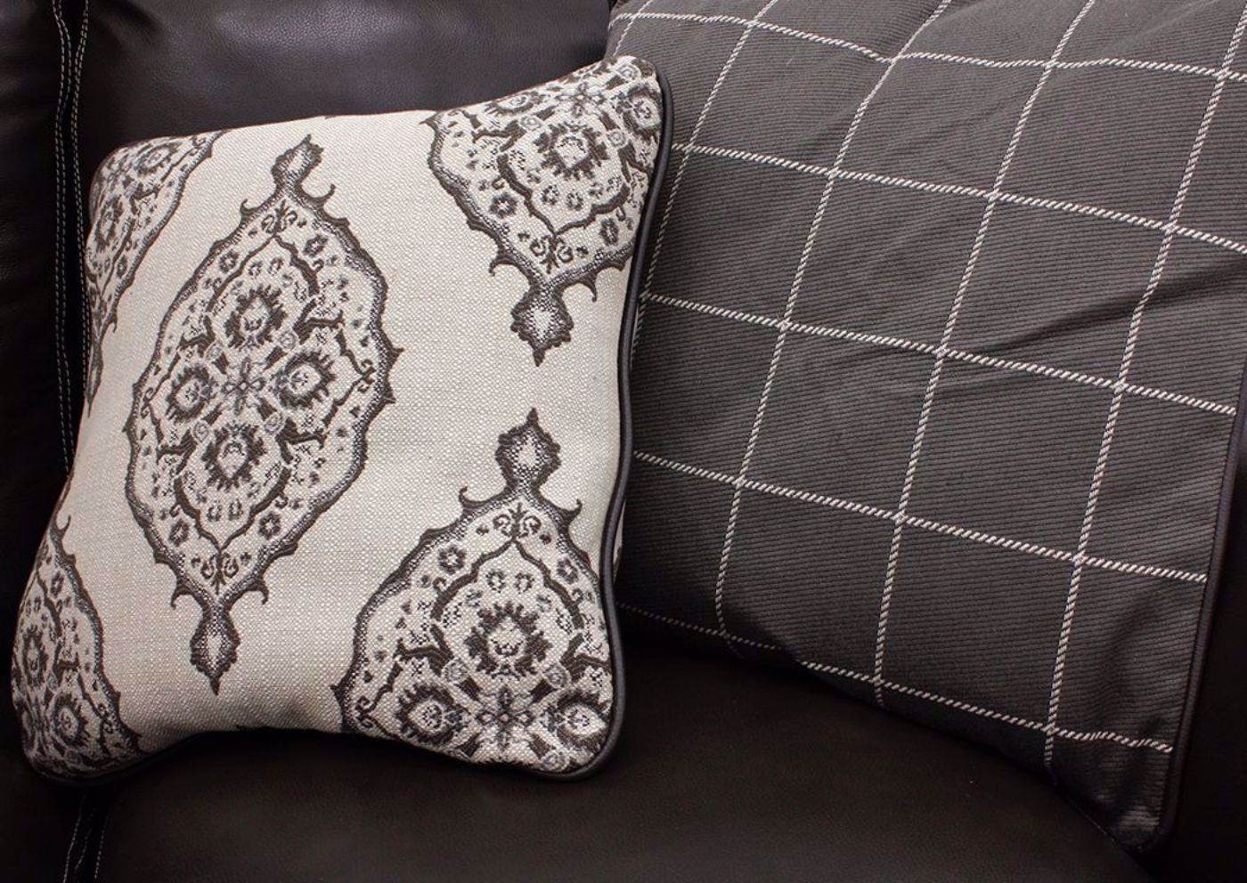 Two Accent Pillows Included with the Amarillo Ghost Sofa and Loveseat by Simon Li Furniture, Patterns Shows are Brown Filigree on Off White Background and Simple Grid on Brown | Home Furniture + Mattress