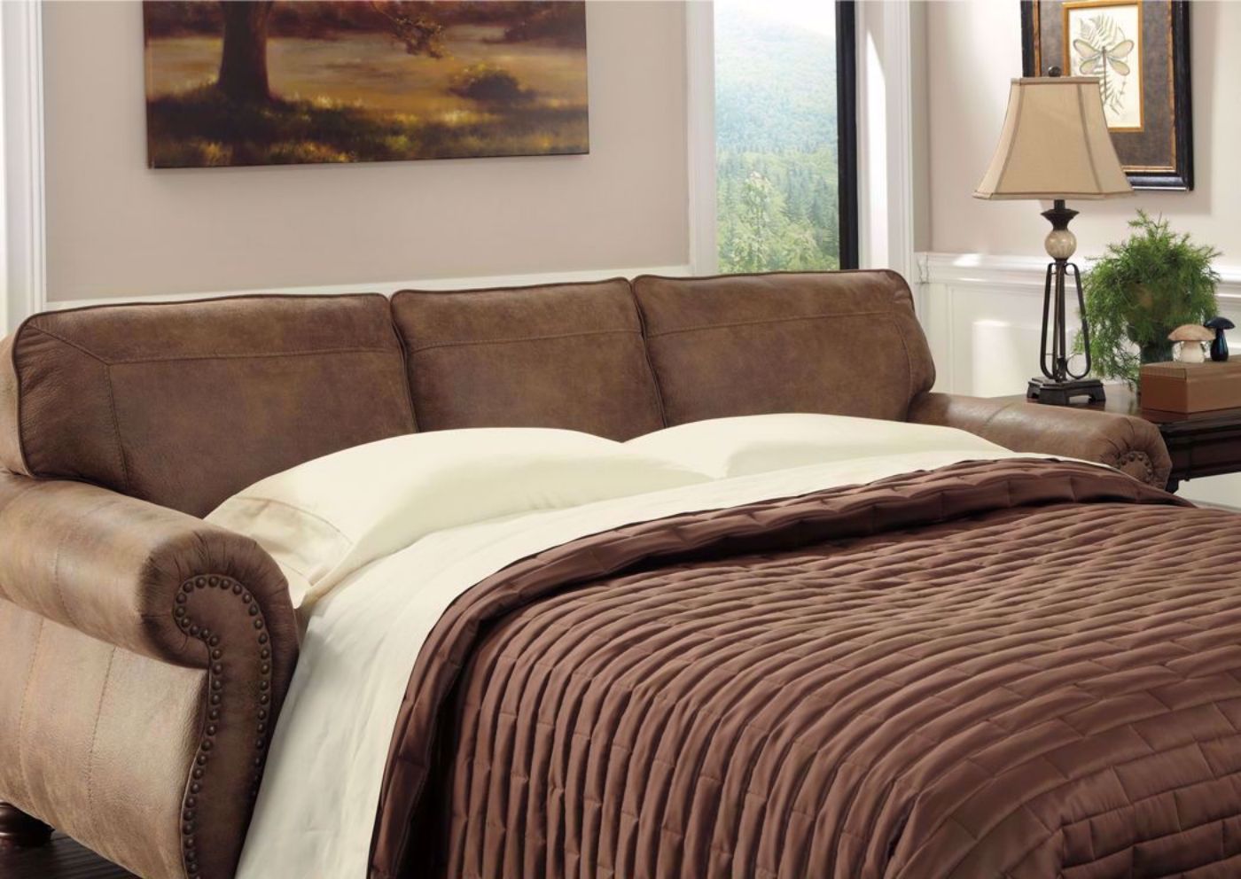 Slightly Angled Larkinhurst Sleeper Sofa by Ashley Furniture Covered in Brown Microfiber Upholstery with 2 Accent Pillows, Sleeper Open, Room View | Home Furniture Plus Bedding