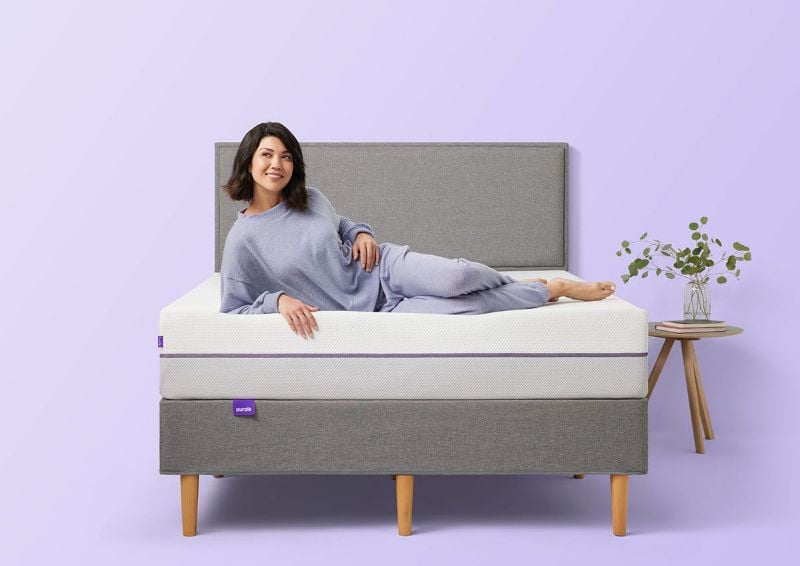 Woman Lounging on the Purple® Hybrid 2 Mattress by Purple® Innovation LLC | Home Furniture Plus Bedding