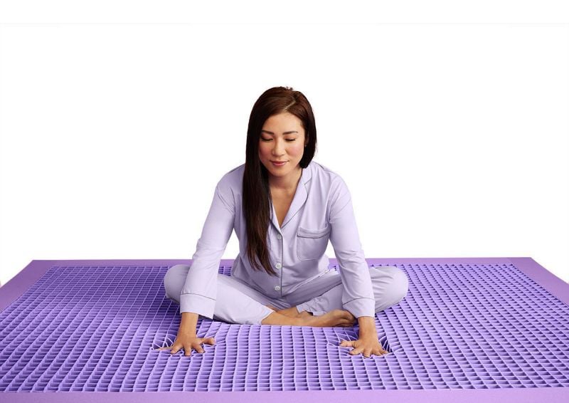 Woman Sitting on the Purple Grid of the Purple®  Mattress by Purple® Innovation LLC | Home Furniture Plus Bedding