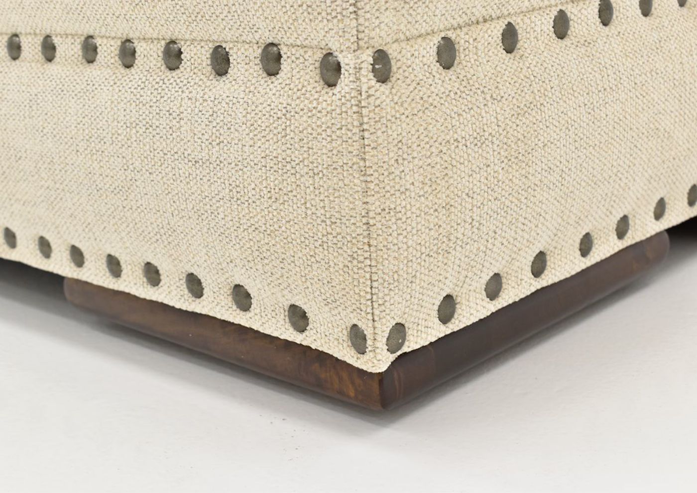 Close Up View of the Nailhead Trim and Oversized Block Feet on the Everette Ottoman in Off-White by Klaussner | Home Furniture Plus Bedding