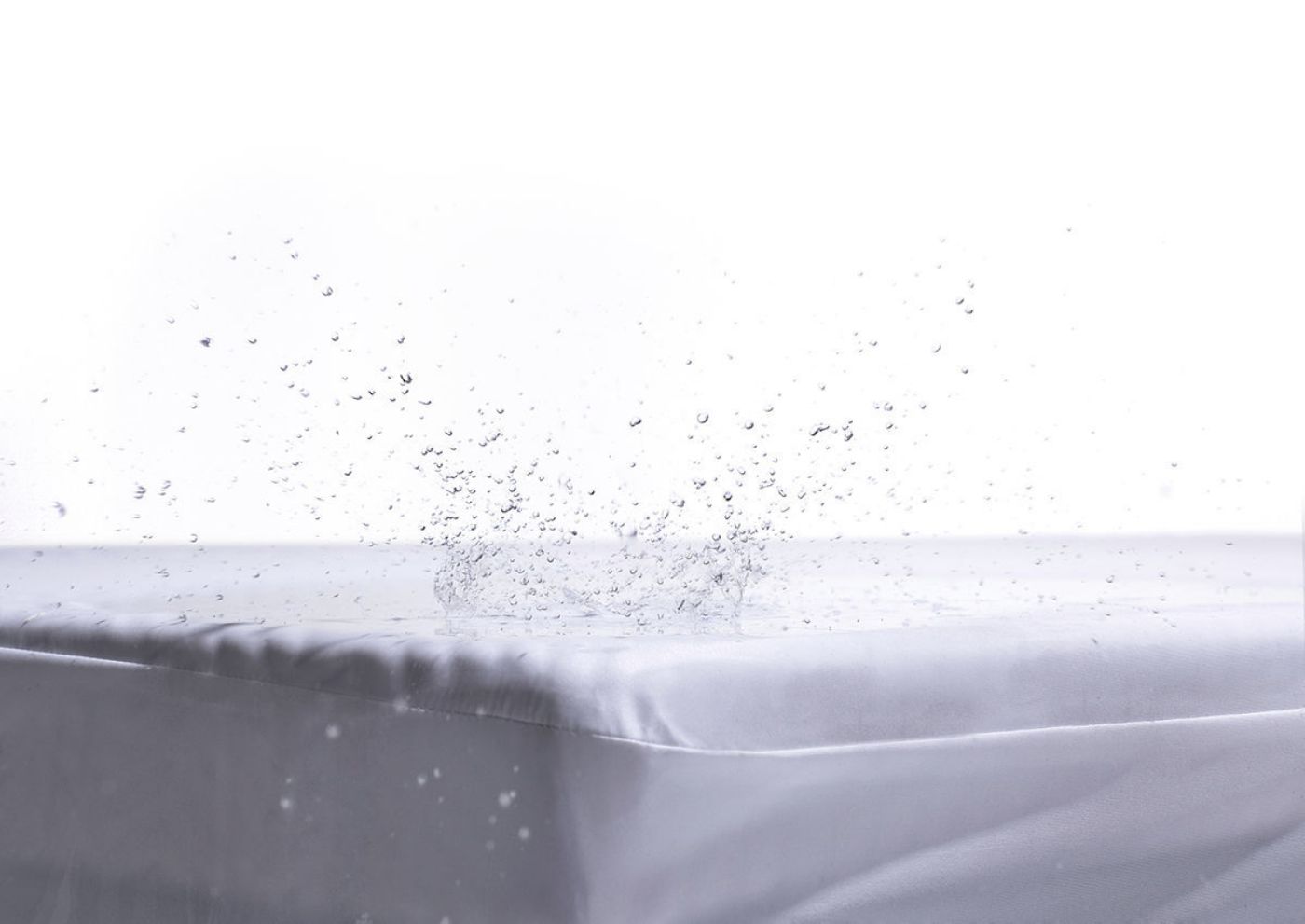 View of Water Splashing against the Deep Pocket Mattress Protector in Queen by Purple® | Home Furniture Plus Bedding