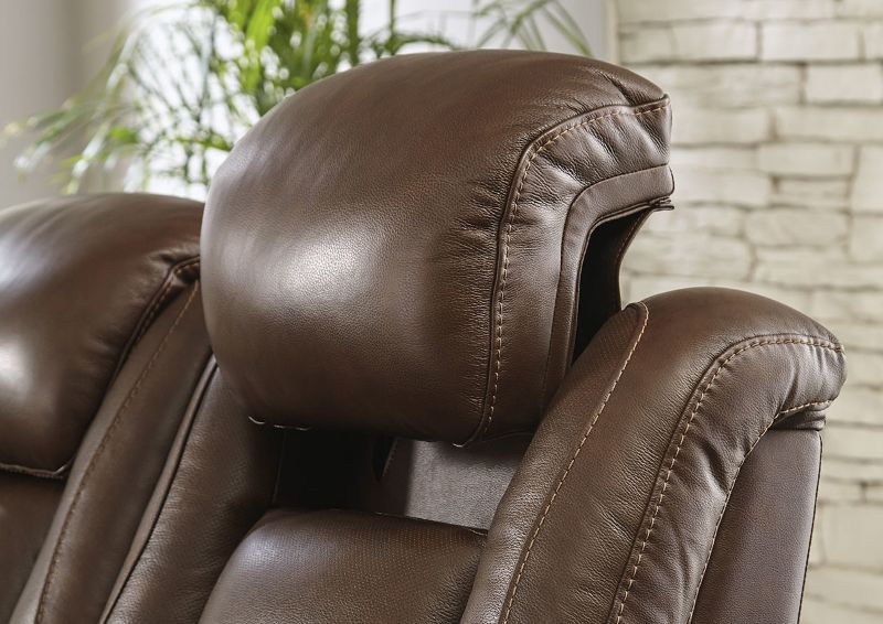 Close Up View of the Extended Headrest on the Man-Den Power Reclining Sofa Set in Mahogany Brown by Ashley Furniture | Home Furniture Plus Bedding