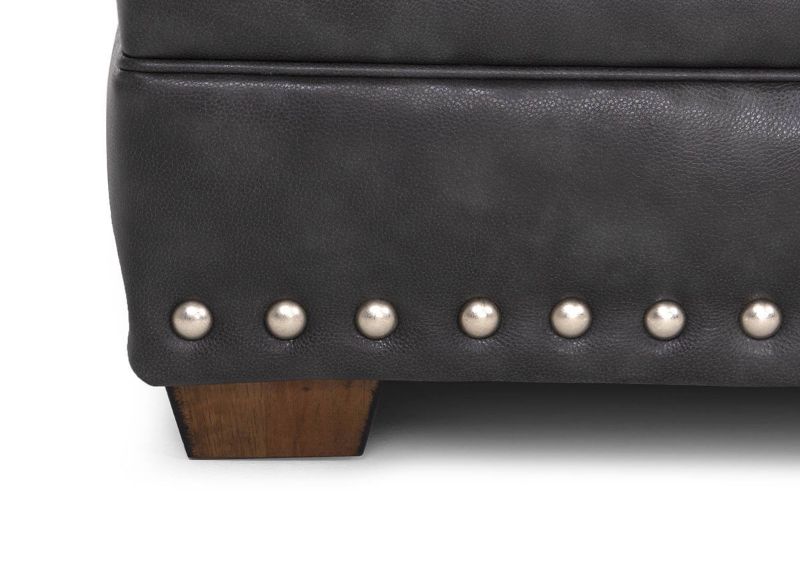 Close Up View of the Wooden Foot and the Nailhead Trim on the Della Leather Ottoman in Gray by Franklin Corporation | Home Furniture Plus Bedding