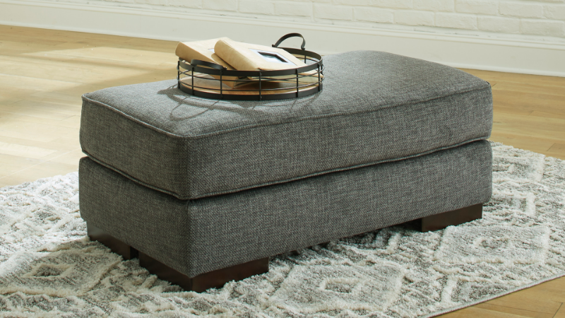 Lessinger Ottoman with Pewter Gray Upholstery in Room Setting | Home Furniture Plus Bedding