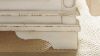 Close Up View of the Detailing on the Footboard of the Realyn Queen Upholstered Panel Bed in Off White by Ashley Furniture | Home Furniture Plus Bedding